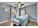 Comfortable bedroom showcases wood-look tile, a metal-framed bed, and dual windows at 19300 Lonesome Pine Dr, Land O Lakes, FL 34638