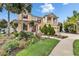 Stately home with a beautifully landscaped front yard, featuring a vibrant lawn and mature palm trees at 19300 Lonesome Pine Dr, Land O Lakes, FL 34638