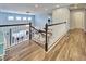 Hallway featuring wood-look tile floors, railing overlooking the great room, and neutral wall color at 19300 Lonesome Pine Dr, Land O Lakes, FL 34638