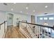 Hallway featuring decorative wall, wood-look tile floors, and a view of the living room below at 19300 Lonesome Pine Dr, Land O Lakes, FL 34638