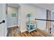 Hallway featuring wood-look tile floors and neutral walls with railing overlooking living room at 19300 Lonesome Pine Dr, Land O Lakes, FL 34638