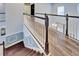 Hallway with wood-look tile floors, white railing, and view of the living area below at 19300 Lonesome Pine Dr, Land O Lakes, FL 34638