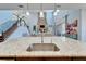 Granite kitchen island with an undermount sink and views of the living room at 19300 Lonesome Pine Dr, Land O Lakes, FL 34638