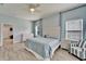 Inviting bedroom with neutral blue walls, wood-look tile floor, and ample natural light at 19300 Lonesome Pine Dr, Land O Lakes, FL 34638