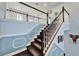 Carpeted staircase with decorative white trim molding set against a neutral blue wall color at 19300 Lonesome Pine Dr, Land O Lakes, FL 34638