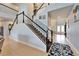 Staircase with carpeted steps, white and black railing, and tiled flooring at entry at 19300 Lonesome Pine Dr, Land O Lakes, FL 34638