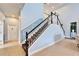 Staircase with carpeted steps, white and black railing, and tiled flooring at 19300 Lonesome Pine Dr, Land O Lakes, FL 34638