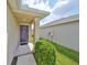Front entrance with a purple door and well-maintained shrubs at 16903 Peaceful Valley Dr, Wimauma, FL 33598