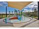 Community splash pad features a shaded area, slide, and spray features for  at 16903 Peaceful Valley Dr, Wimauma, FL 33598