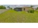 Large backyard with grassy lawn and screened patio at 16903 Peaceful Valley Dr, Wimauma, FL 33598
