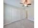 Bright bedroom with ceiling fan, carpet, and double-door closet at 16903 Peaceful Valley Dr, Wimauma, FL 33598