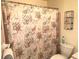 Clean bathroom with seashell shower curtain and storage at 100 Bluff View Dr # 605A, Belleair Bluffs, FL 33770