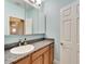 Bathroom with granite countertop, wood cabinets, and a mirrored medicine cabinet at 19300 Lonesome Pine Dr, Land O Lakes, FL 34638