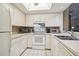 Bright kitchen features white cabinets and a full suite of appliances at 4137 Edgewood Dr, Holiday, FL 34691