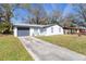 Charming one-story home with a driveway, front yard, and a gray garage door at 3432 Danny Bryan Blvd, Tampa, FL 33619