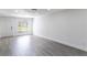 Large, bright living room featuring laminate flooring, fresh paint, and a window to the front yard at 3432 Danny Bryan Blvd, Tampa, FL 33619