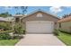 House exterior featuring a two-car garage and manicured lawn at 16252 Amethyst Key Dr, Wimauma, FL 33598
