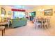 Open living and dining area with green sofa and access to a patio at 16252 Amethyst Key Dr, Wimauma, FL 33598