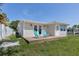 Newly renovated home with a deck, lawn, and white fence at 2624 Society Dr, Holiday, FL 34691