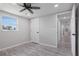 Bright bedroom with ceiling fan and grey wood-look flooring at 2624 Society Dr, Holiday, FL 34691