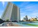 Eye-level view of a sleek, modern high-rise condominium building under a blue sky at 2910 W Barcelona St # 903, Tampa, FL 33629