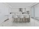 Modern white kitchen features sleek cabinetry, stainless appliances, island with seating, and stylish marble floors at 2910 W Barcelona St # 903, Tampa, FL 33629