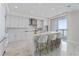 Modern kitchen featuring marble floors, white cabinetry, island with seating, and stainless appliances at 2910 W Barcelona St # 903, Tampa, FL 33629