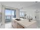 Bright kitchen with island, stainless appliances, and sliding glass doors offering picturesque waterfront views at 2910 W Barcelona St # 903, Tampa, FL 33629