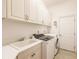 Bright laundry room with washer, dryer, cabinets, and a utility sink at 225 Pesaro Dr, North Venice, FL 34275