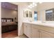 Clean bathroom with double sinks, a shower, and a view into a bedroom at 225 Pesaro Dr, North Venice, FL 34275
