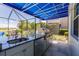 Outdoor kitchen with granite countertop and stainless steel appliances at 225 Pesaro Dr, North Venice, FL 34275