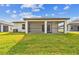 Green backyard with covered patio; perfect for outdoor relaxation at 12744 Wanderlust Pl, Parrish, FL 34219