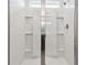 Modern bathroom shower with glass doors, chrome fixtures, and bright white tile at 12744 Wanderlust Pl, Parrish, FL 34219