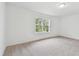 Spacious bedroom with neutral carpeting and large window at 12744 Wanderlust Pl, Parrish, FL 34219