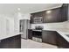 Modern kitchen with dark cabinets, stainless steel appliances, and a large countertop at 12744 Wanderlust Pl, Parrish, FL 34219