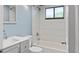 Updated bathroom with gray vanity, white toilet and bathtub, and light blue walls at 11702 Raintree Village Blvd # A, Temple Terrace, FL 33617