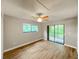 Bright bedroom featuring wood-look floors and sliding glass doors to balcony at 11702 Raintree Village Blvd # A, Temple Terrace, FL 33617