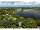 An aerial view showcasing a lakefront property with a home and dock at 2925 W Sligh Ave, Tampa, FL 33614