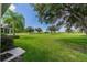 Large backyard with green grass and distant trees at 1940 Inverness Greens Dr # 1940, Sun City Center, FL 33573