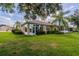 Home's back elevation, showcasing sunroom and green lawn at 1940 Inverness Greens Dr # 1940, Sun City Center, FL 33573