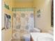 Clean bathroom with shower, toilet, and decorative shower curtain at 1940 Inverness Greens Dr # 1940, Sun City Center, FL 33573