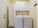 Laundry room with washer, dryer, and ample storage cabinets at 1940 Inverness Greens Dr # 1940, Sun City Center, FL 33573