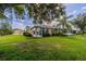 Home's back elevation, showcasing sunroom and green lawn at 1940 Inverness Greens Dr # 1940, Sun City Center, FL 33573