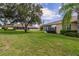 Home's back elevation, showcasing sunroom and green lawn at 1940 Inverness Greens Dr # 1940, Sun City Center, FL 33573