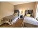 Bright bedroom with twin beds, side tables, and large window offering natural light and neutral colors at 6504 Abaco Dr # 101, Apollo Beach, FL 33572