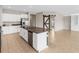 Open kitchen with island, white cabinets, granite countertops, and a barn door at 5474 Leslie Canyon Dr, Wimauma, FL 33598