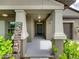 Front entry with covered porch, decorative columns, and a dark green door at 5474 Leslie Canyon Dr, Wimauma, FL 33598