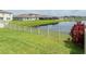 Backyard with pond view, vinyl fence, and lush lawn at 5474 Leslie Canyon Dr, Wimauma, FL 33598