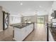 Open concept kitchen with large island, stainless steel appliances and view to backyard at 5474 Leslie Canyon Dr, Wimauma, FL 33598