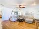 Bright living room with hardwood floors, large sectional sofa, and views into adjacent rooms at 9408 Oak St, Riverview, FL 33578